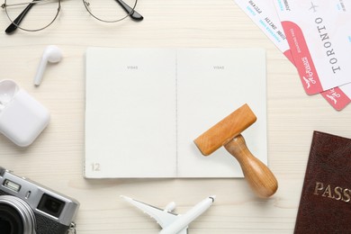 Photo of Flat lay composition with passports, stamp and flight tickets on white wooden table