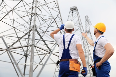 Photo of Professional engineers working on installationelectrical substation outdoors