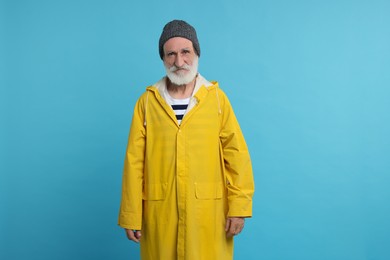 Photo of Fisherman in yellow raincoat on light blue background