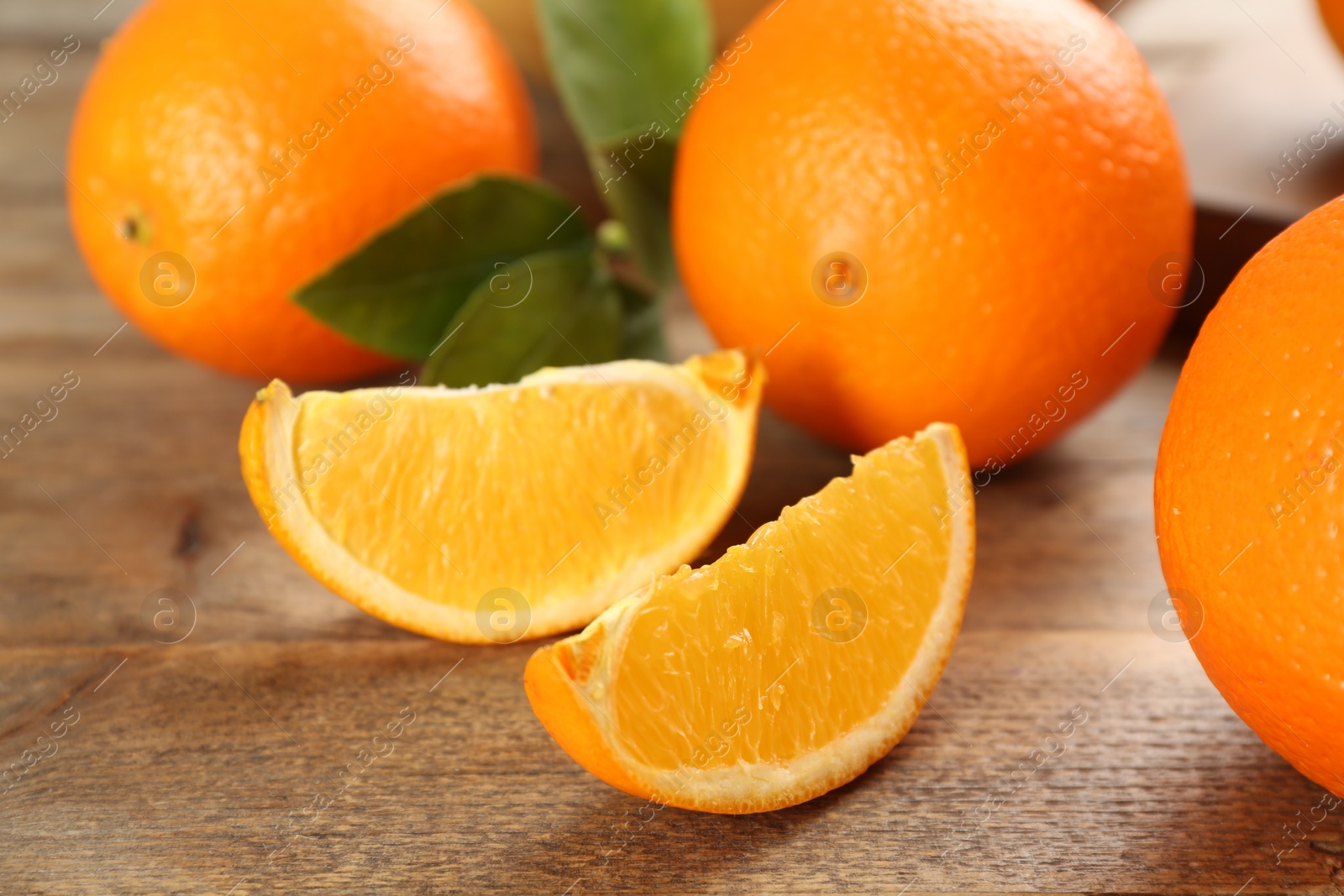 Photo of Delicious ripe oranges on wooden table, closeup