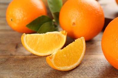 Photo of Delicious ripe oranges on wooden table, closeup