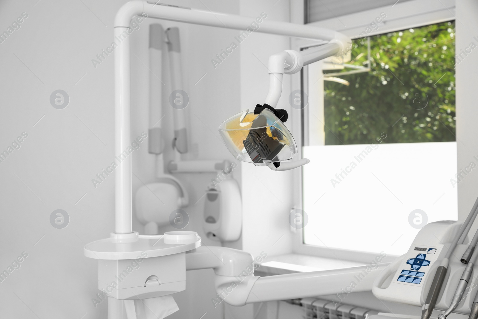 Photo of Professional equipment and special lamp in modern dentist's office
