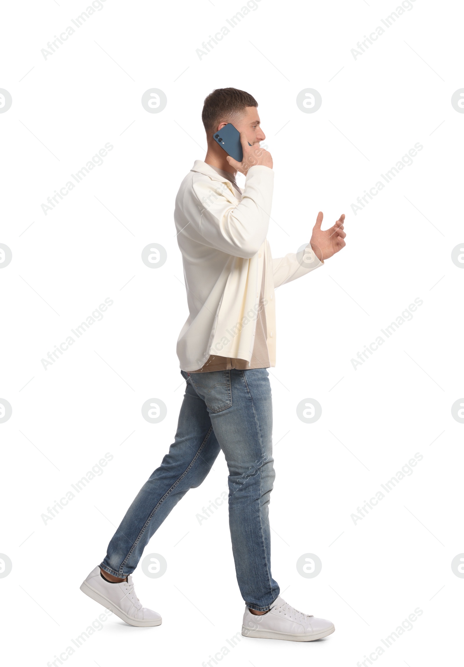 Photo of Man talking on smartphone while walking against white background