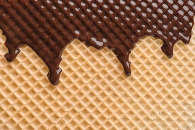 Photo of Hot dark chocolate on wafer, closeup. Crispy food