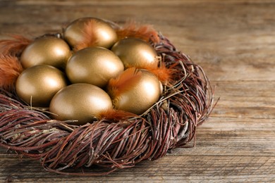 Many golden eggs in nest on wooden table