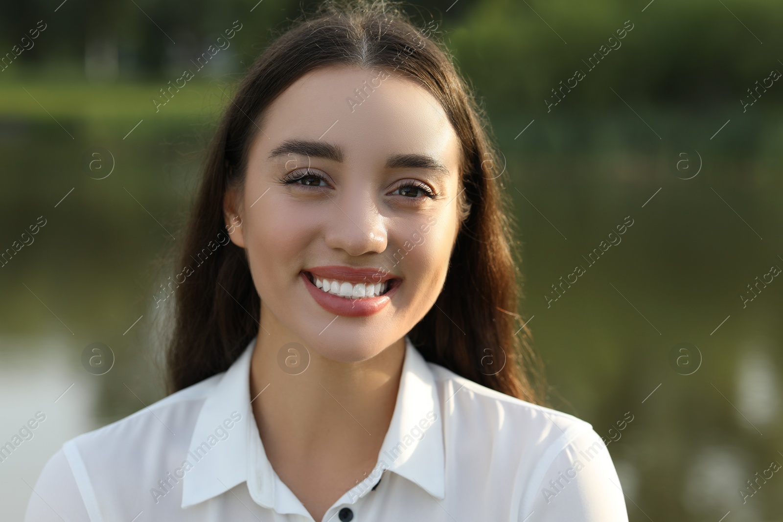 Photo of Portrait of beautiful woman posing on blurred background. Attractive lady smiling and looking into camera