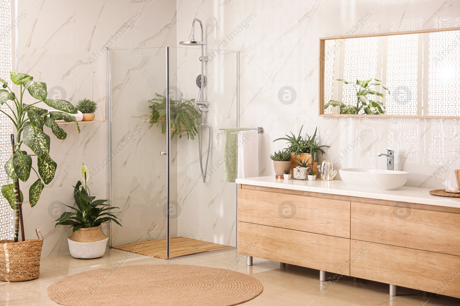 Photo of Stylish bathroom interior with countertop, shower stall and houseplants. Design idea