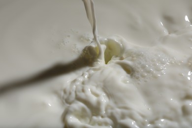 Photo of Pouring delicious fresh milk as background, closeup