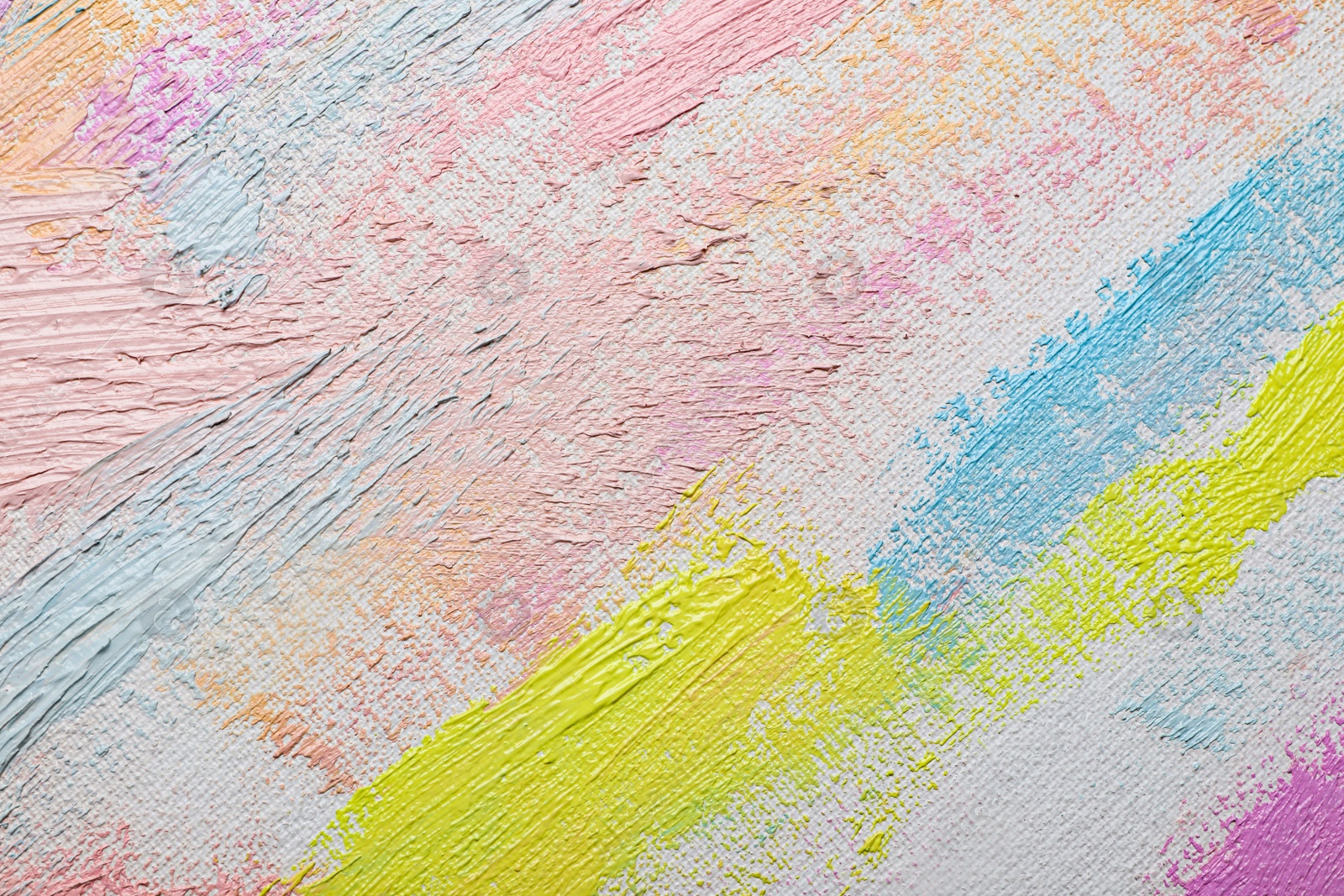 Photo of Strokes of different pastel acrylic paints on white canvas, closeup