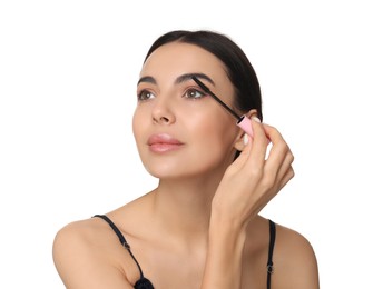 Photo of Beautiful young woman applying mascara on white background