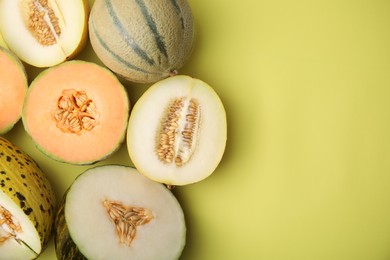 Tasty colorful ripe melons on yellow background, flat lay. Space for text