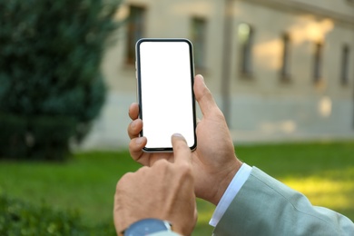 Photo of Man using modern mobile phone outdoors, closeup