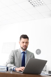 Photo of Male lawyer working with laptop in office