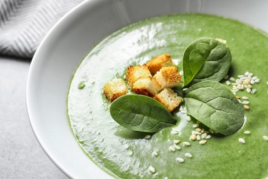 Fresh vegetable detox soup made of spinach with croutons in dish, closeup