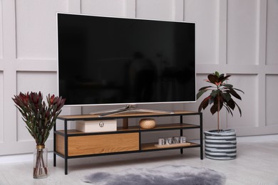 Photo of Stylish room interior with TV on wooden cabinet