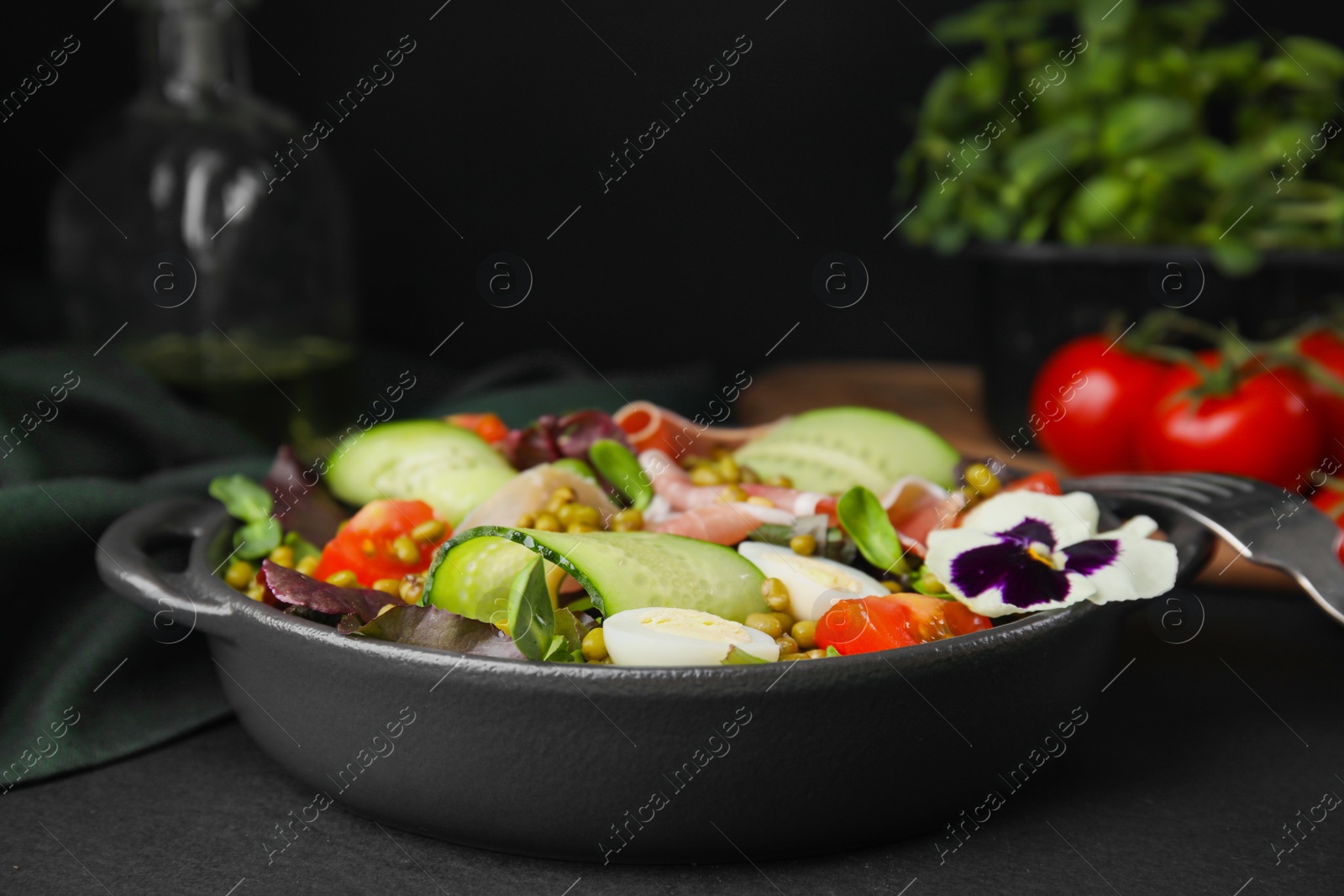 Photo of Bowl of salad with mung beans on black table