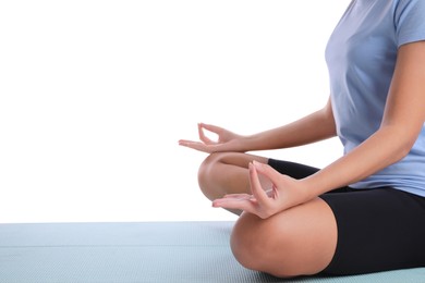 African-American woman meditating on yoga mat against white background, closeup