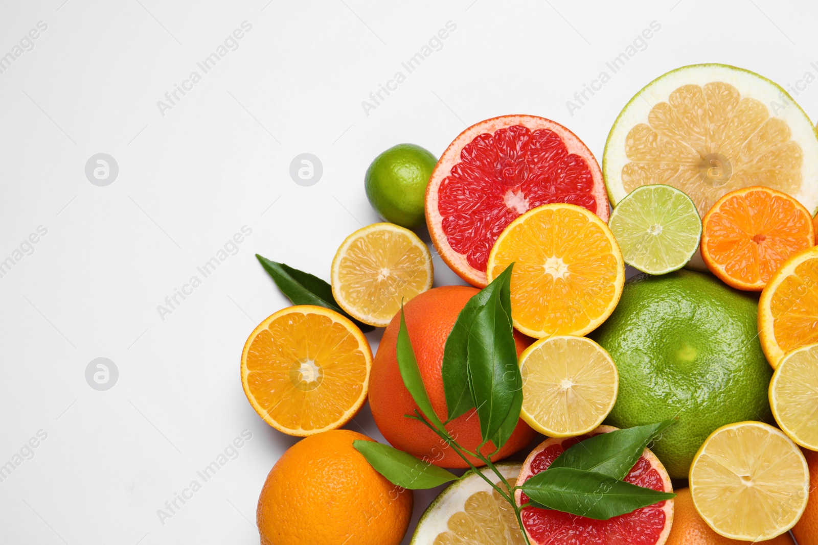 Photo of Different citrus fruits with fresh leaves on white background, top view. Space for text