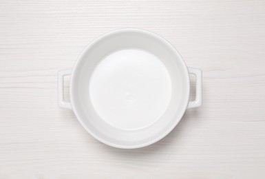 Photo of Empty pot on white wooden table, top view