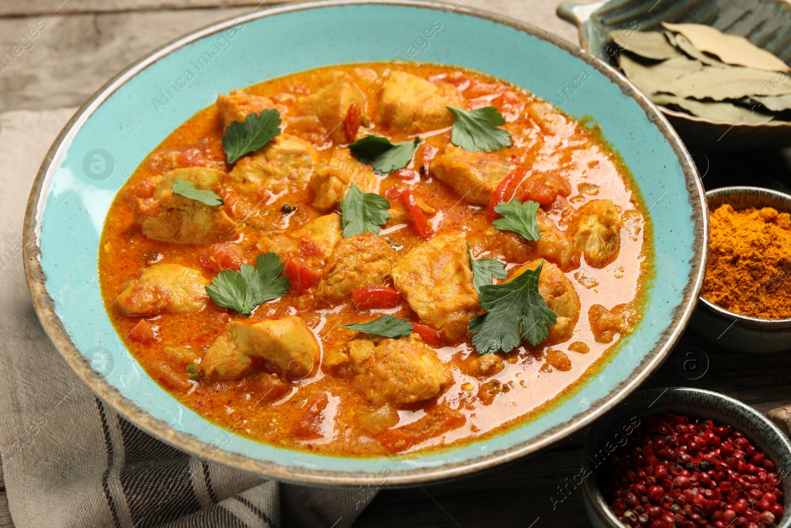 Photo of Delicious chicken curry and ingredients on table, closeup