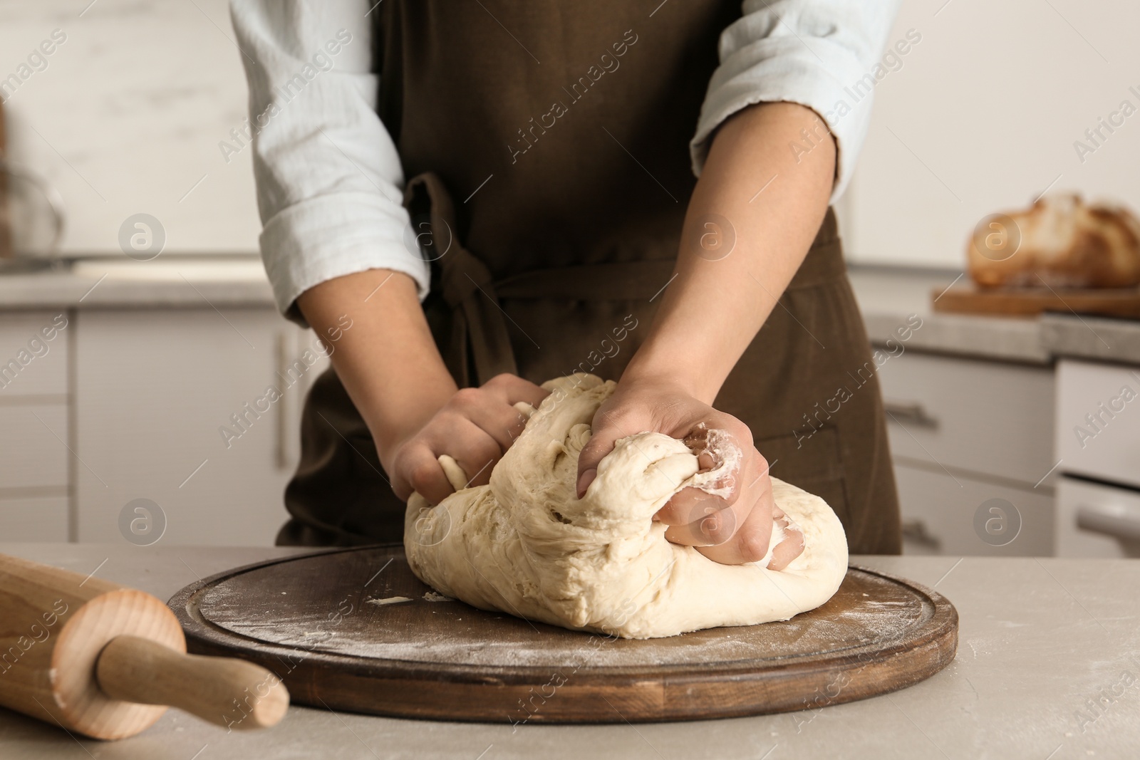 Photo of Female baker preparing bread dough at table, closeup