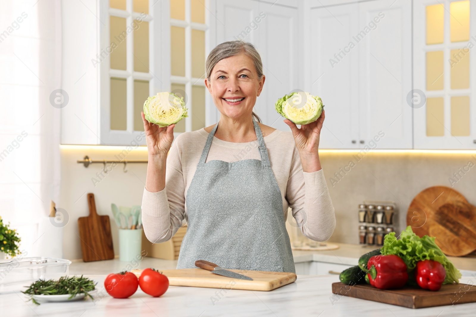 Photo of Happy housewife cooking at table in kitchen