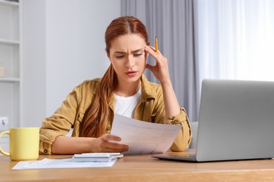 Woman doing taxes at table in room