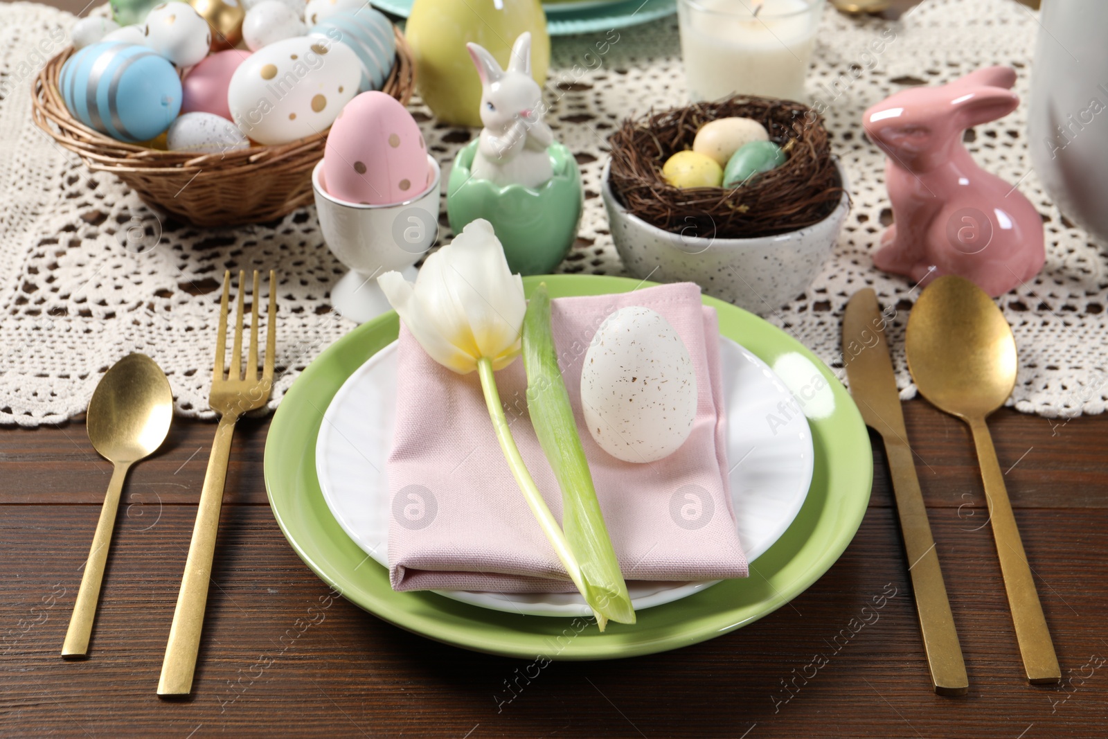 Photo of Festive table setting with painted eggs. Easter celebration