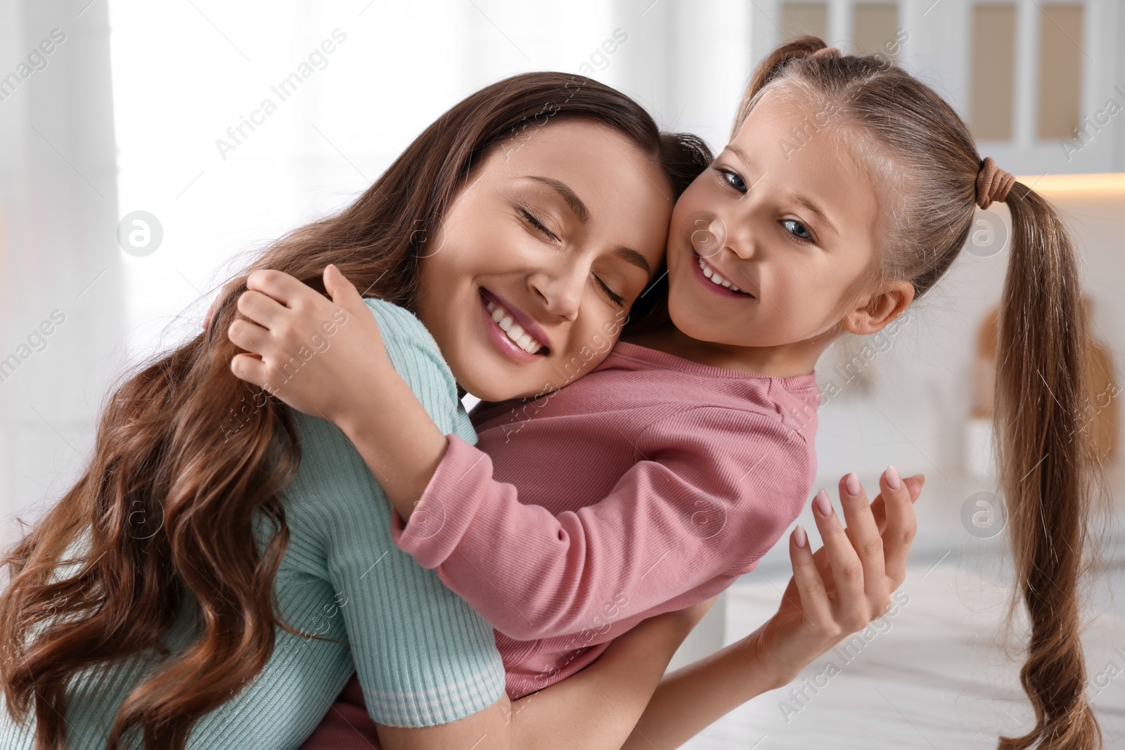 Photo of Happy mother with her cute daughter in kitchen