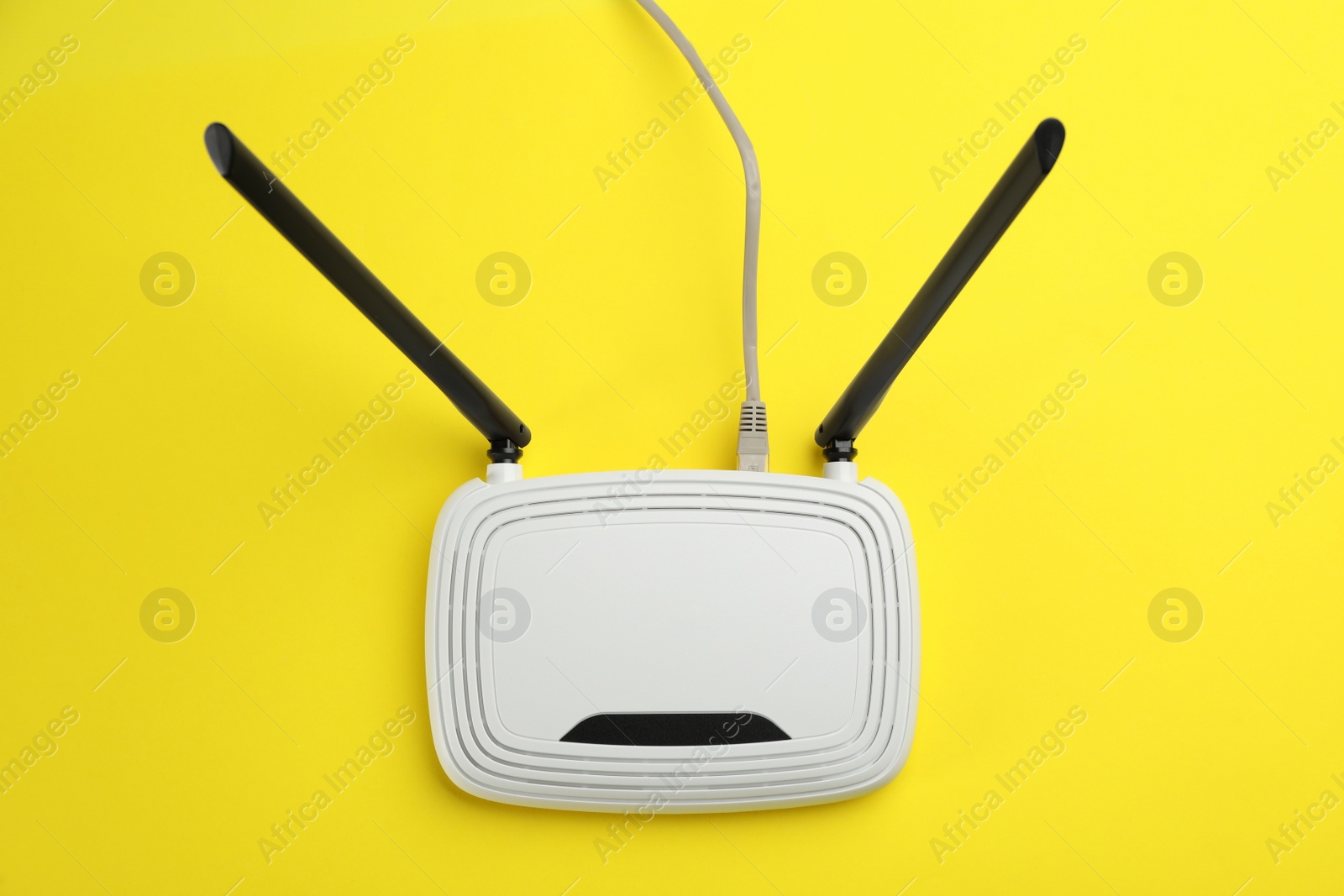 Photo of Modern Wi-Fi router on yellow background, top view