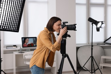 Photo of Professional photographer taking picture in modern photo studio