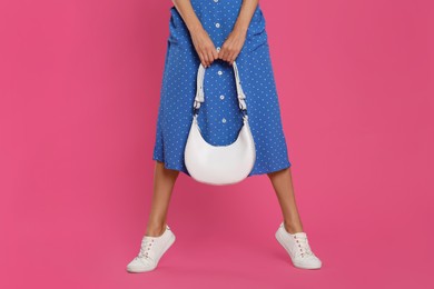 Woman with stylish bag on pink background, closeup