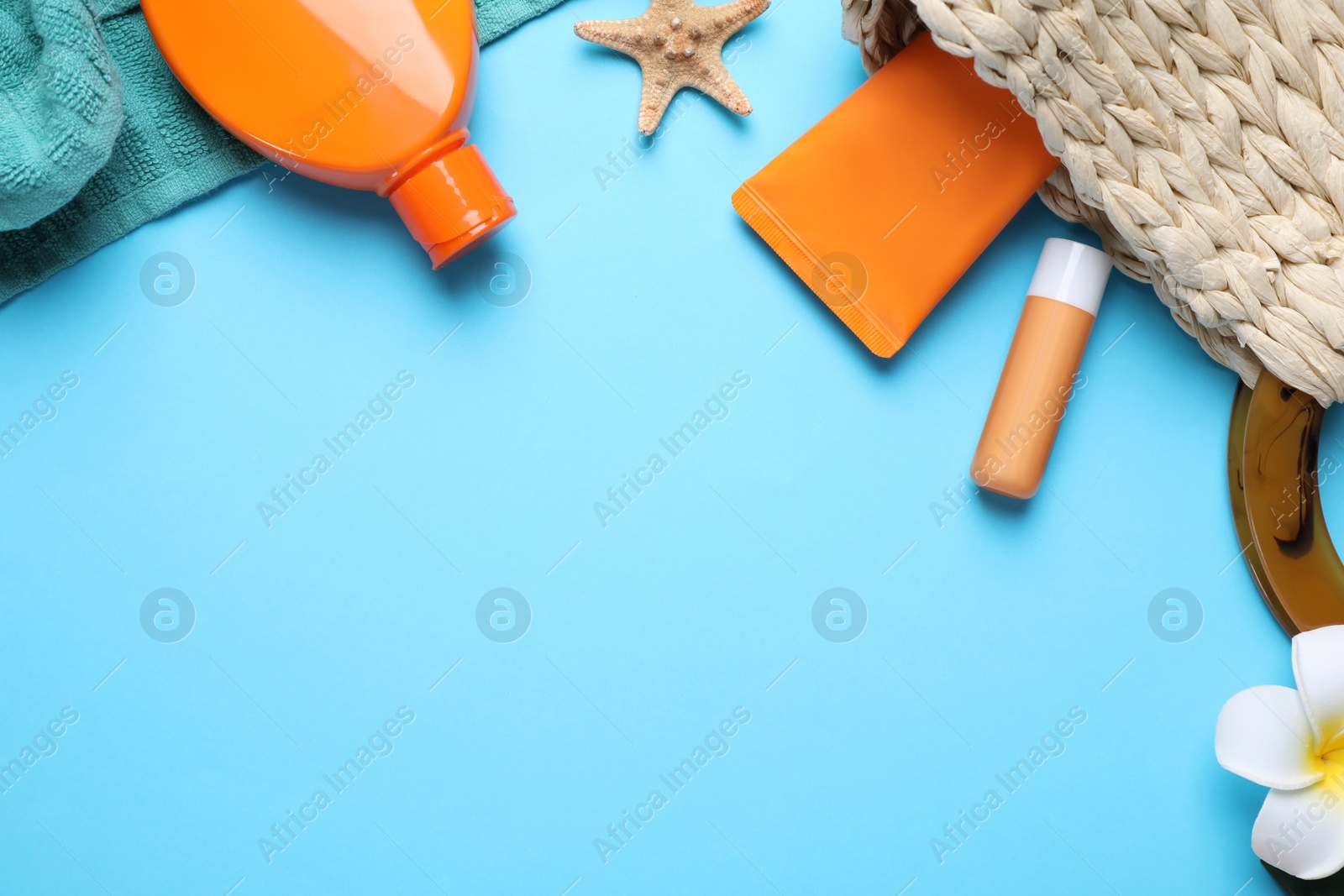 Photo of Sun protection products and beach accessories on light blue background, flat lay. Space for text