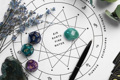 Photo of Gemstones, astrology dices, pen and lavender on zodiac wheel with sign triplicities, flat lay