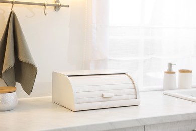 Wooden bread box on white countertop in kitchen