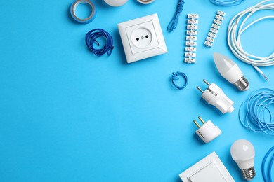 Flat lay composition with electrician's accessories on light blue background, space for text