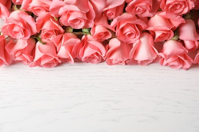 Photo of Beautiful roses on wooden table