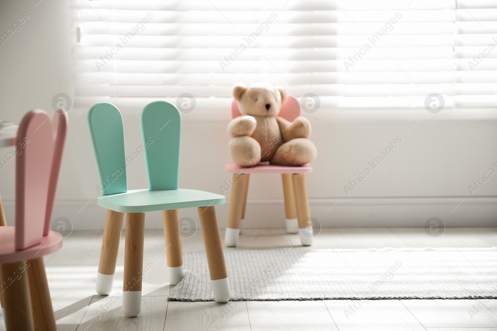 Photo of Cute little chair with bunny ears indoors. Children's room interior
