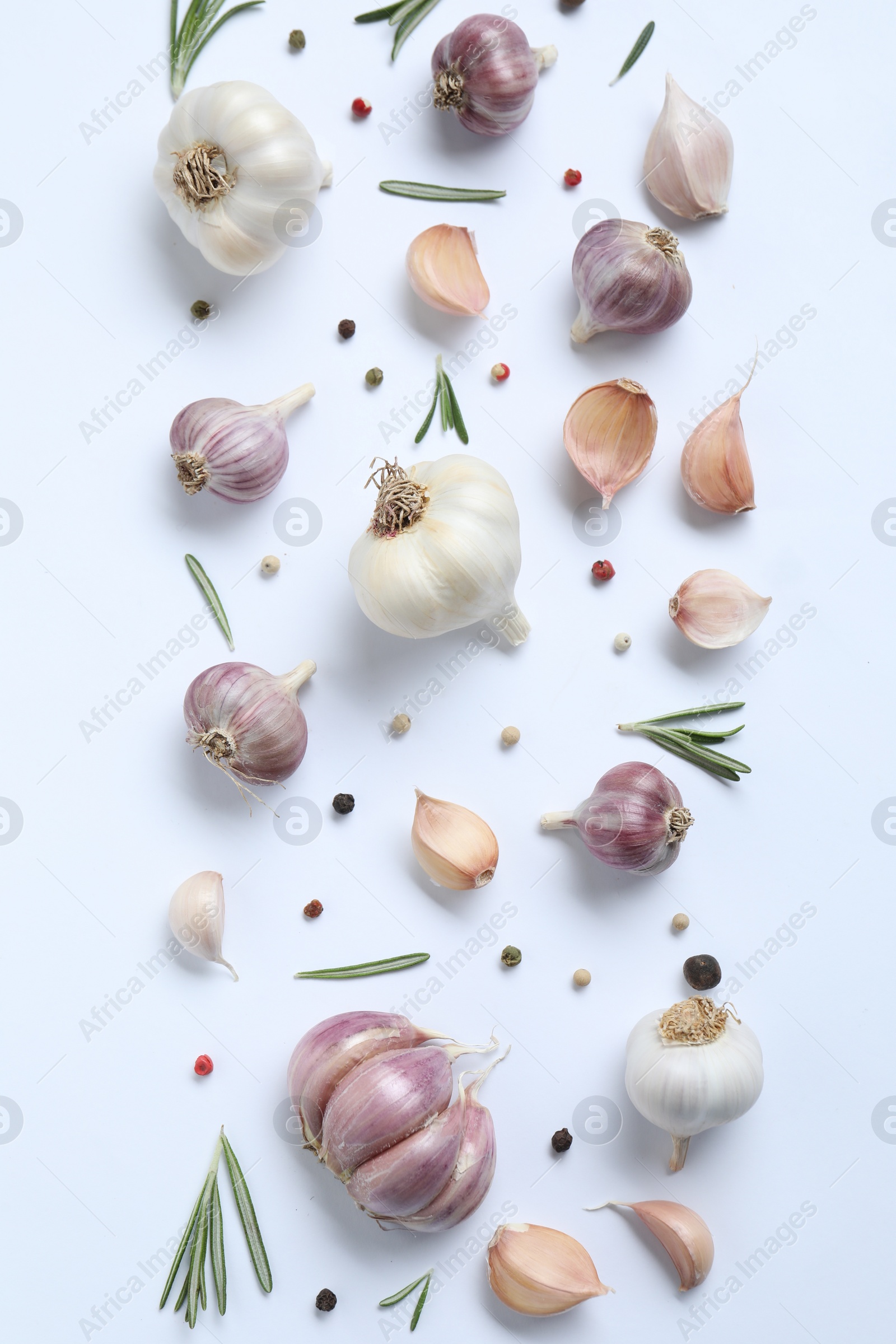 Photo of Fresh garlic, rosemary and peppercorns on white background, flat lay