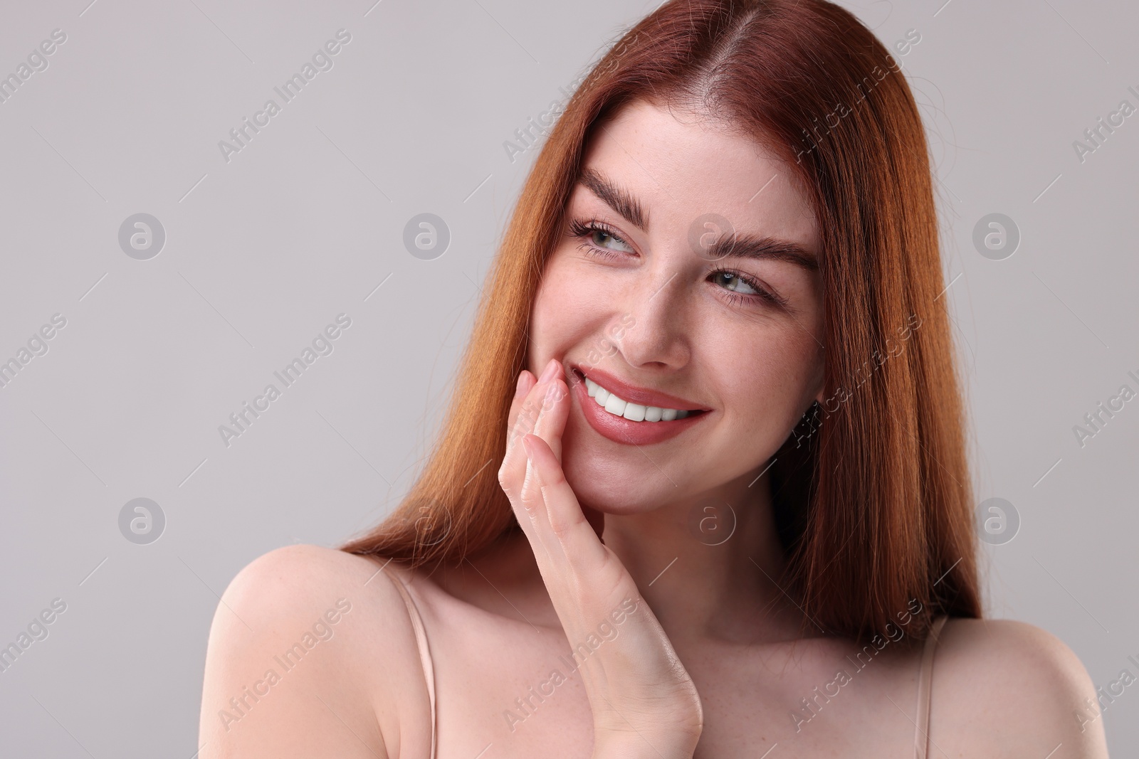 Photo of Portrait of smiling woman on grey background, closeup