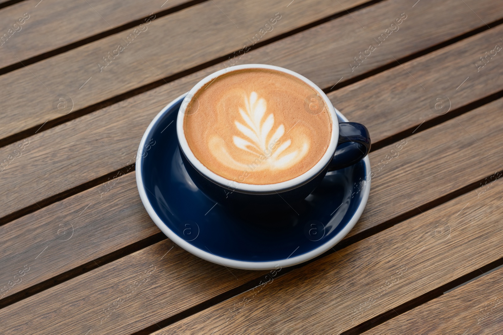 Photo of Cup of aromatic coffee on wooden table