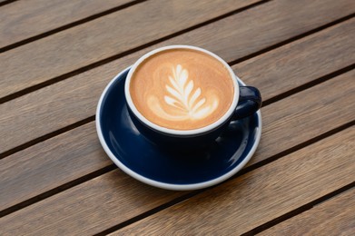 Photo of Cup of aromatic coffee on wooden table