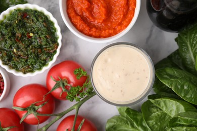 Photo of Different marinades and products on white marble table, flat lay