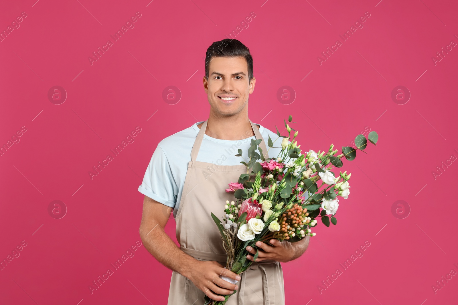 Photo of Florist with beautiful bouquet on pink background