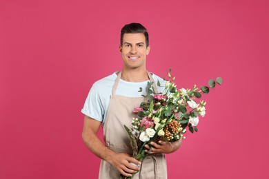 Florist with beautiful bouquet on pink background