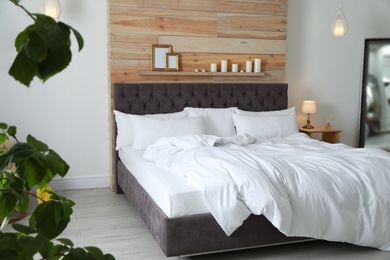 Large comfortable bed in stylish room. Modern interior design