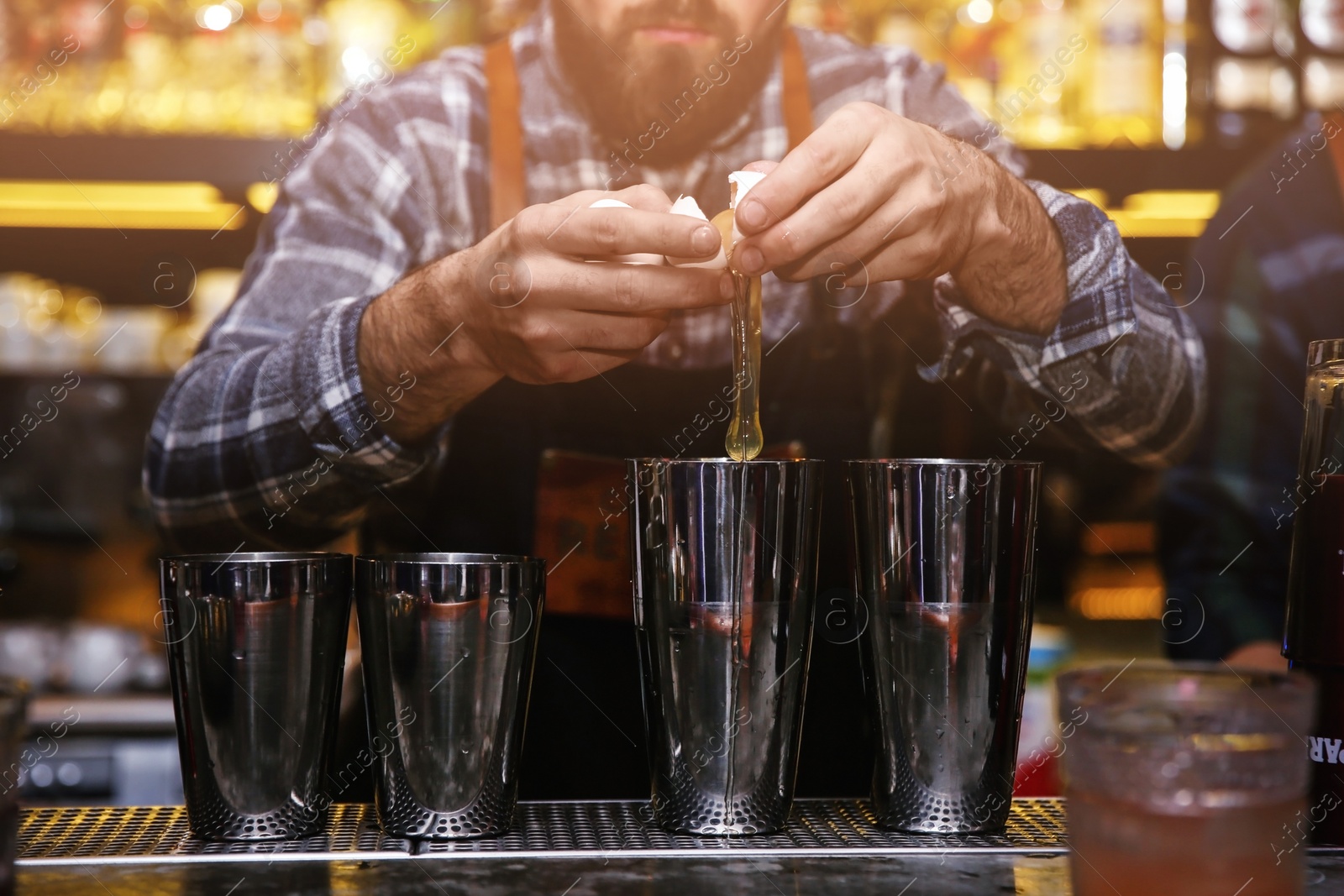 Photo of Bartender preparing tasty cocktail at counter in nightclub, closeup