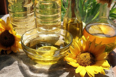 Photo of Organic sunflower oil and flowers on fabric, closeup