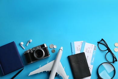 Photo of Flat lay composition with toy airplane and travel items on light blue background. Space for text