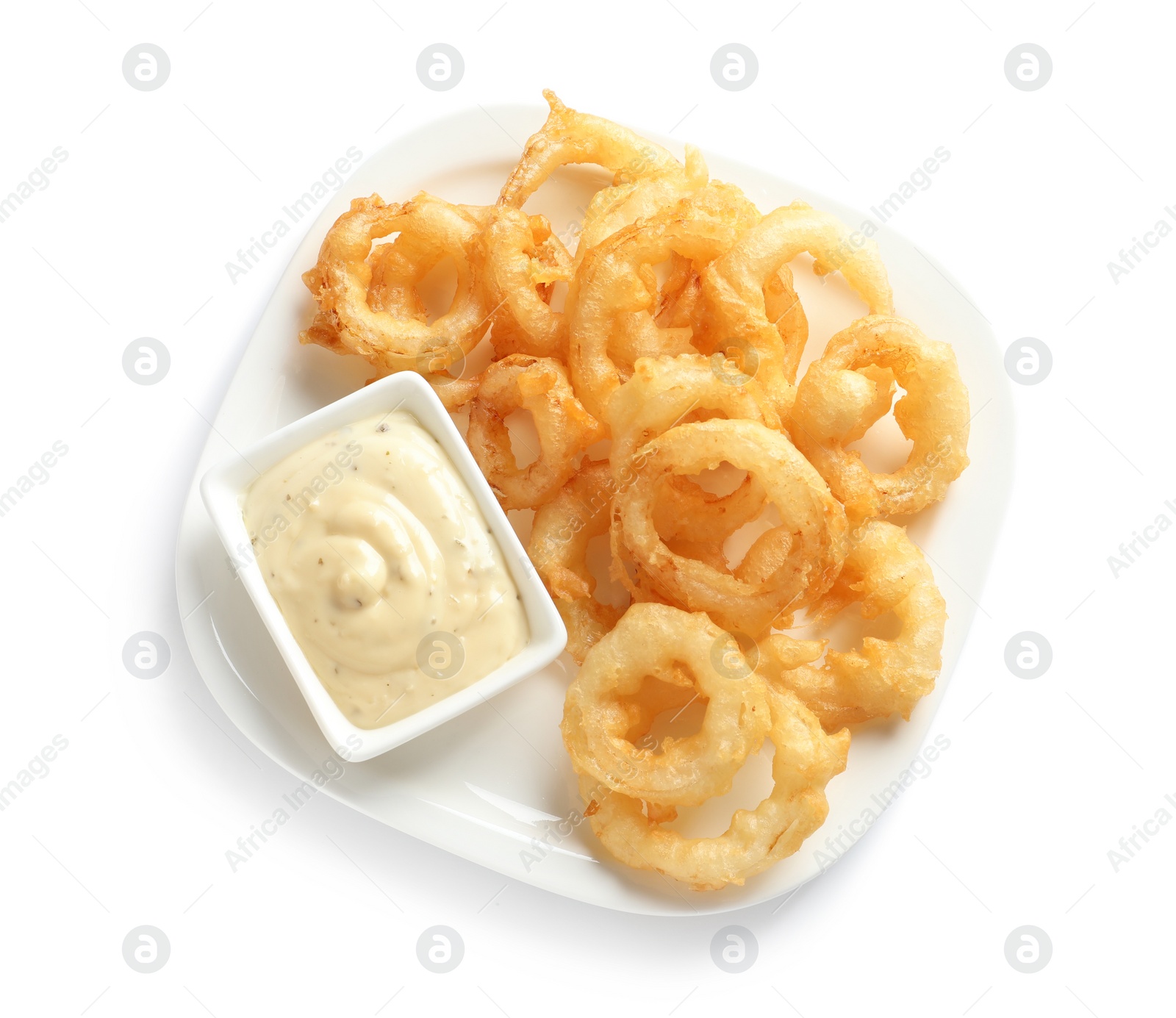 Photo of Plate with delicious crispy onion rings and sauce on white background, top view